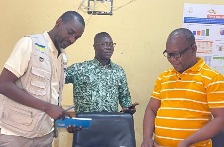 Trois membres de l’équipe du projet RACINE examinent ensemble un document de travail devant un ordinateur portable.